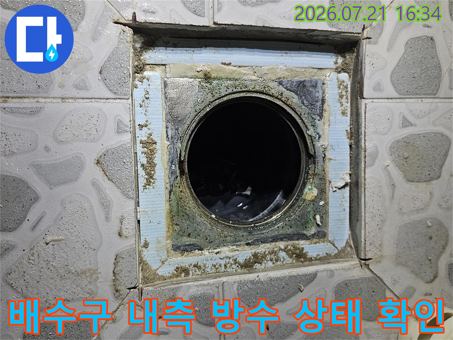 어질러진 타일 조각 사이로 노출된 화장실 배수구 내부 모습