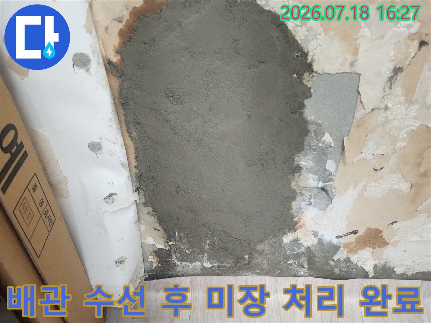 벽지가 제거된 벽면에 시멘트 미장을 통해 배관 부위를 마감한 모습