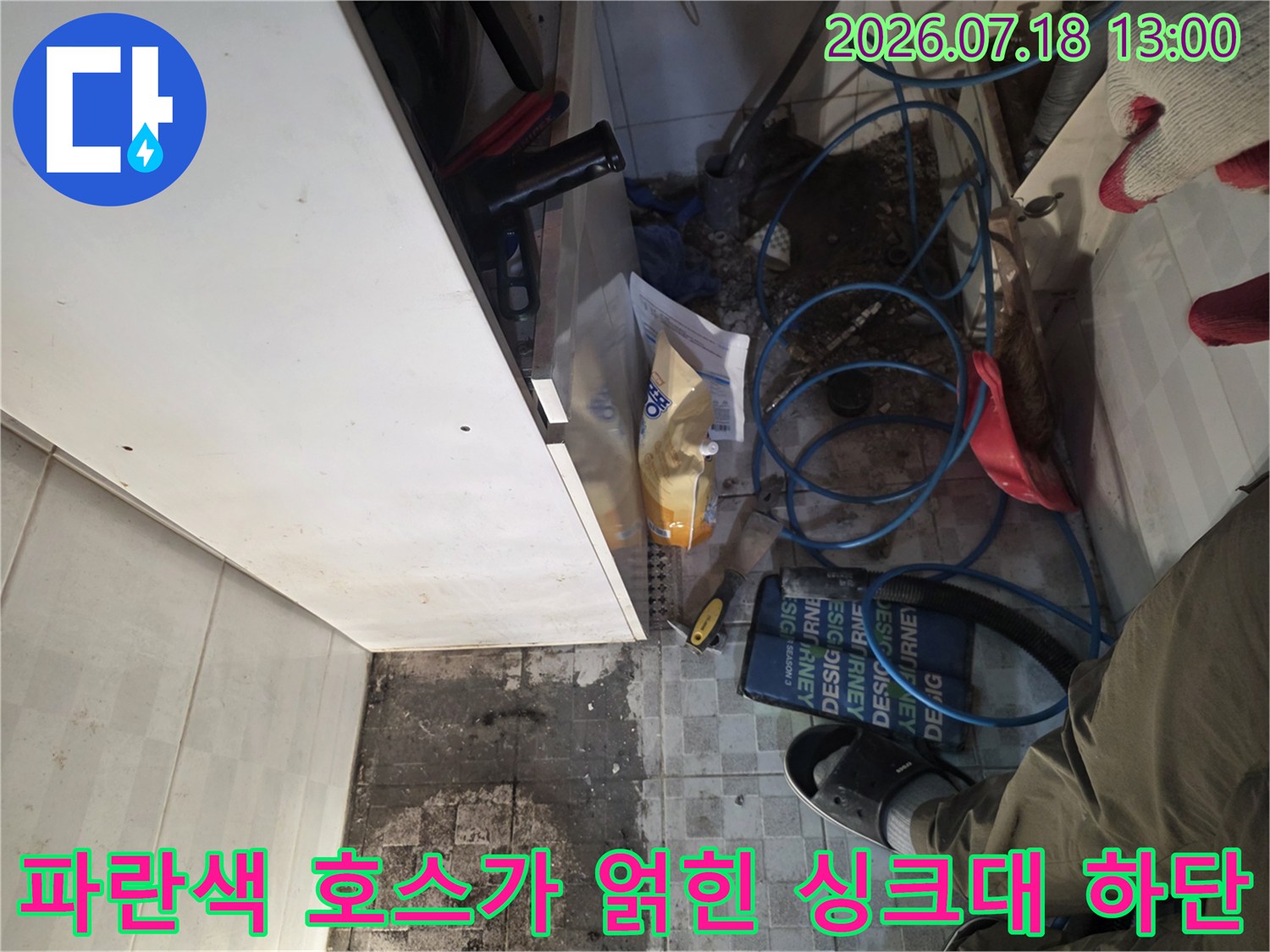 복잡하게 연결된 파란색 배관과 물 얼룩이 심한 바닥 타일-사진