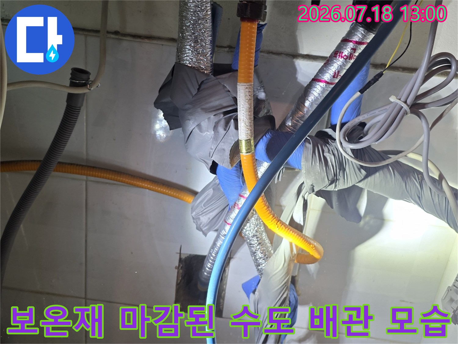 은색 보온재와 파란색 호스가 교차하며 연결된 주방 배관-상세사진