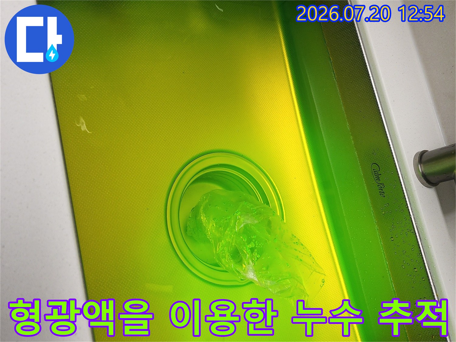 노란색 액체가 담긴 싱크대 내부와 배수구-누수 진단을 위한 형광 염료 투입 장면-사진