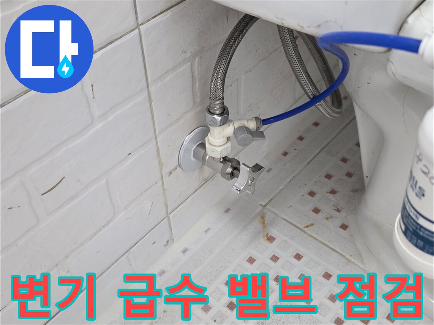 벽면 타일 사이의 수도 밸브와 변기 연결 호스 상세 모습