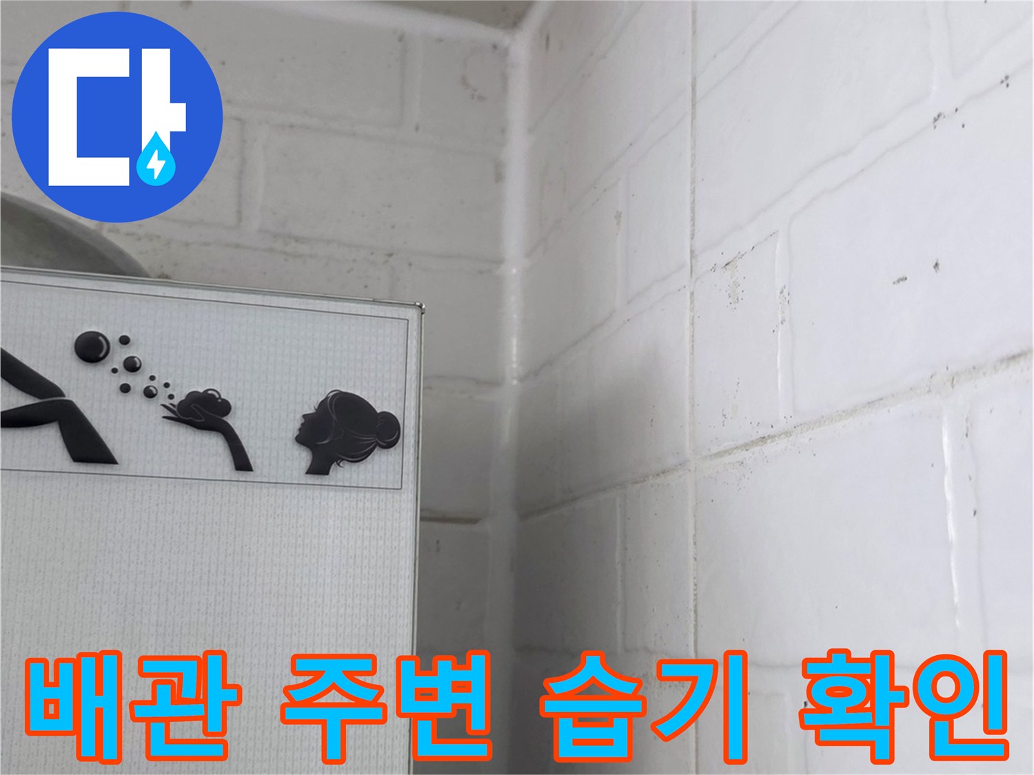 점검구 내부의-하얀색 타일 벽면과-배관 연결 부위 근접 촬영