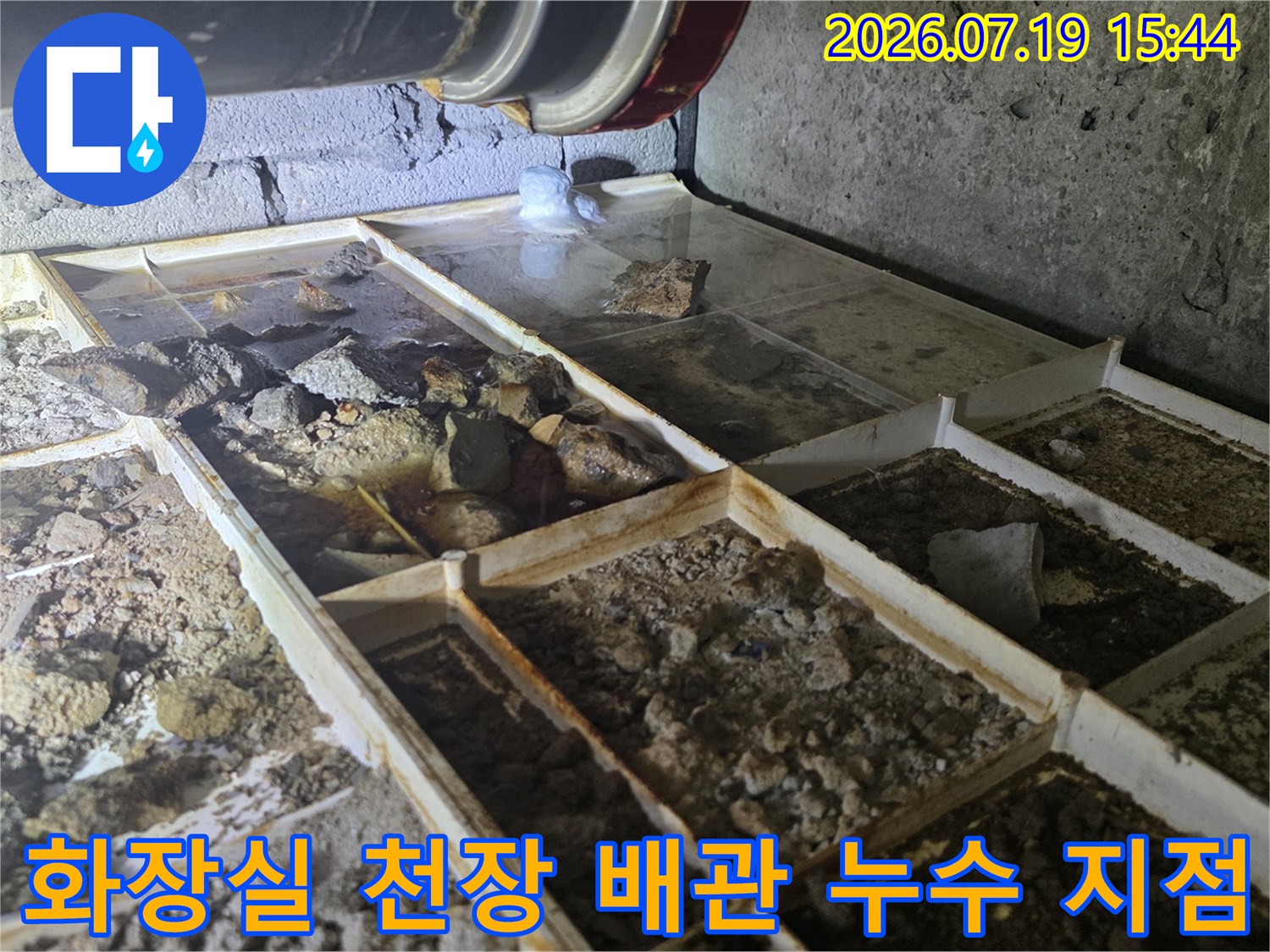 화장실-천장-내부의-검은색-배관과-그-주변으로-물에-젖어-부식된-콘크리트-바닥면