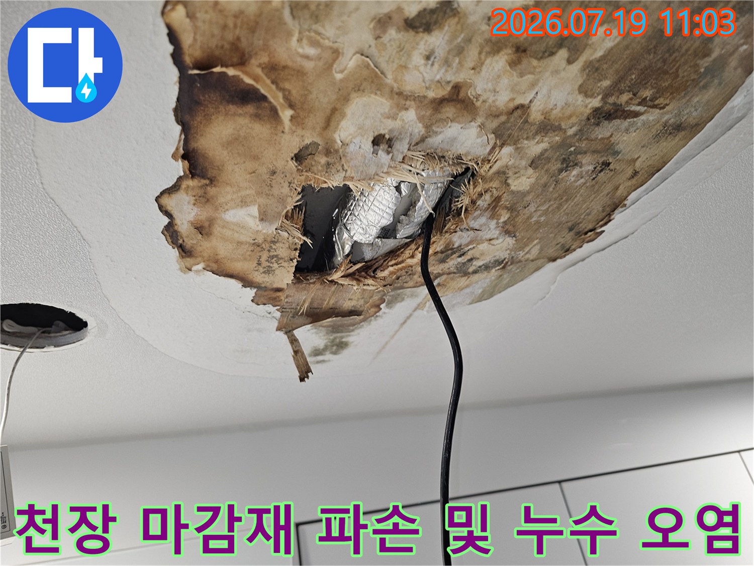 누수로 인해 갈색으로 변한 천장재와 내부의 은색 단열재가 노출된 사진