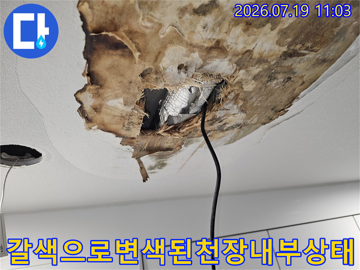 누수로 인해 갈색으로 오염된 천장 자재-내부의 은색 단열재가 드러난 모습