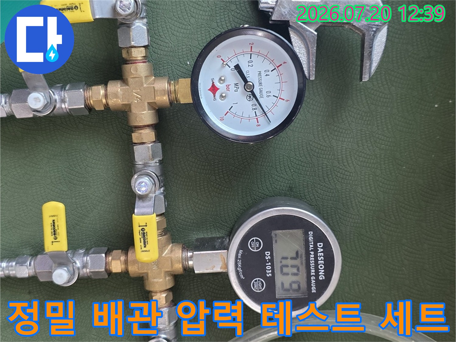 노란색 손잡이 밸브와 디지털 게이지가 연결된 누수 탐지 장비 사진