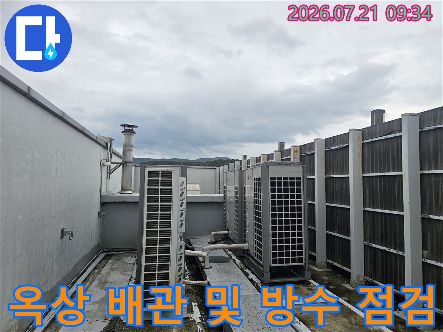 옥상에 설치된 대형 환기 설비와 노출 배관 시스템을 점검하는 모습