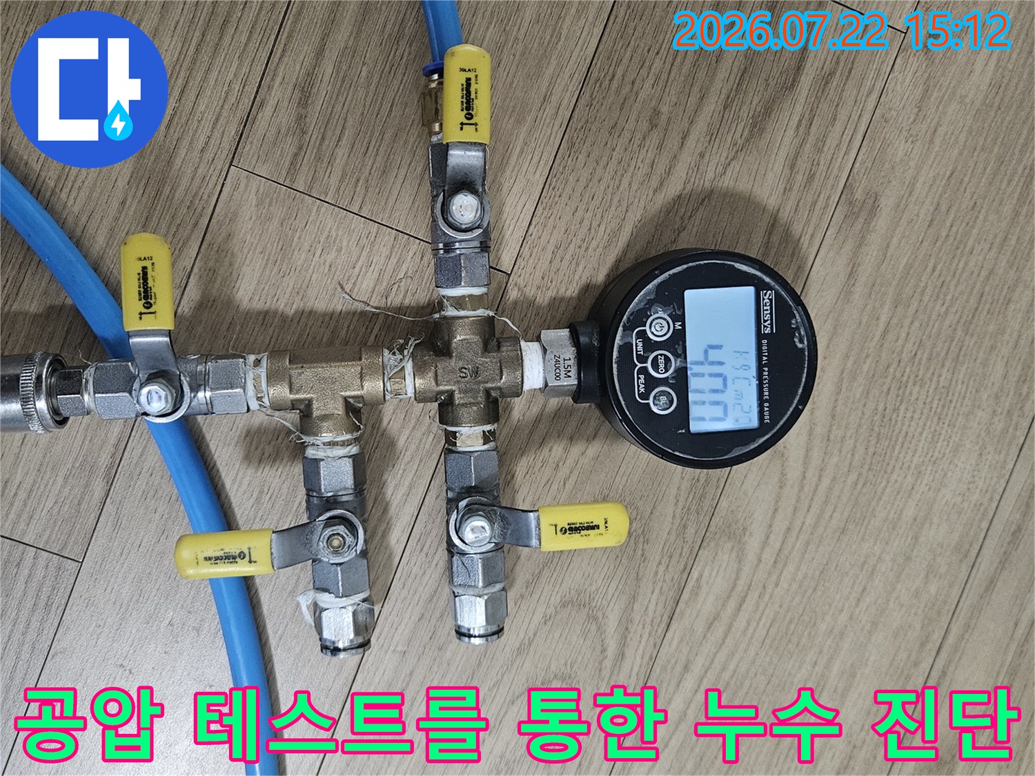 디지털-압력계와 파란색 호스 및 밸브들이 복합적으로 연결된 측정 장치