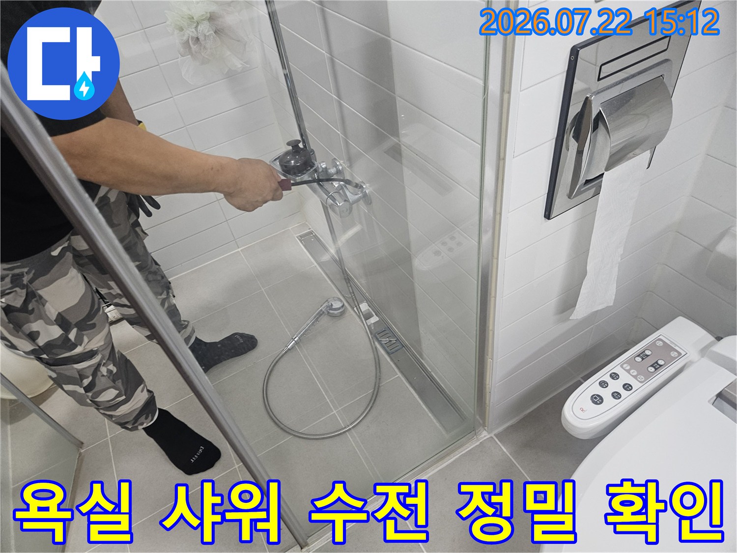 샤워 부스 내 설치된 금속제 수전 밸브를 손으로 만지며 점검 중인 엔지니어의 모습