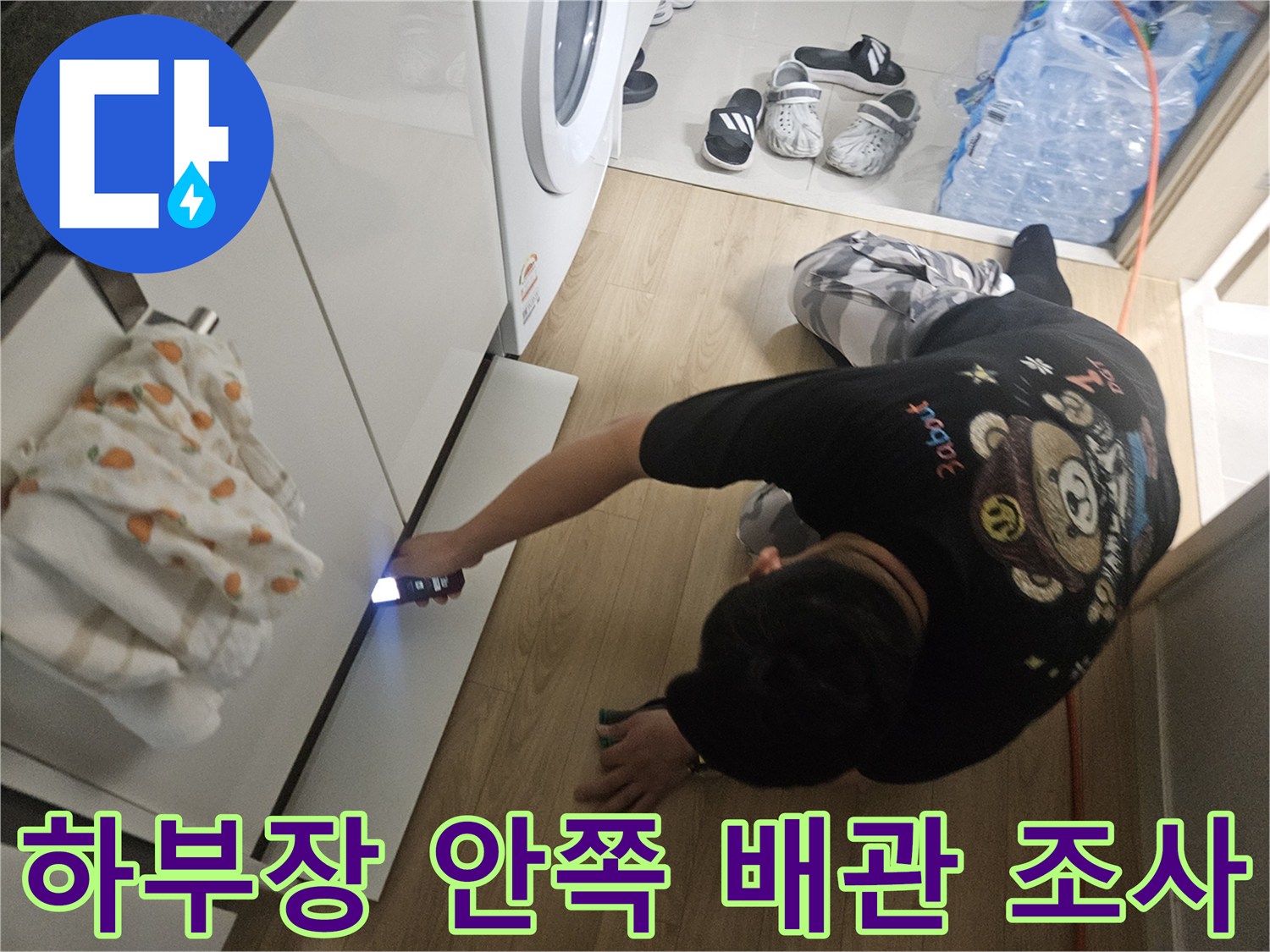 싱크대-아래쪽-어두운-배관-부위를-손전등으로-비추는-작업