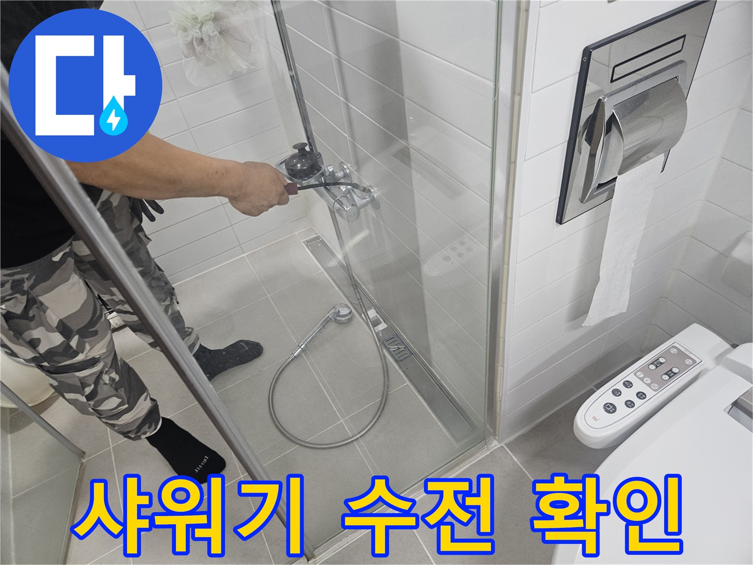 욕실 타일 벽면에 설치된 샤워 수전을 엔지니어가 점검하고 있는 장면