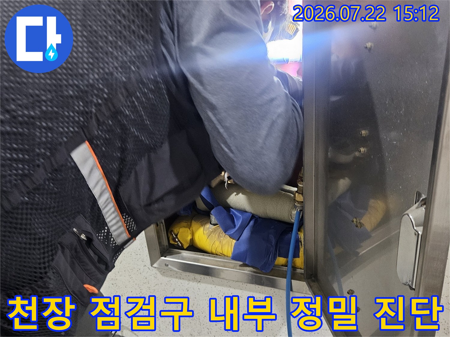 작업자가 화장실 천장 점검구를 열고 내부 배관 상태를 세밀하게 확인하는 모습