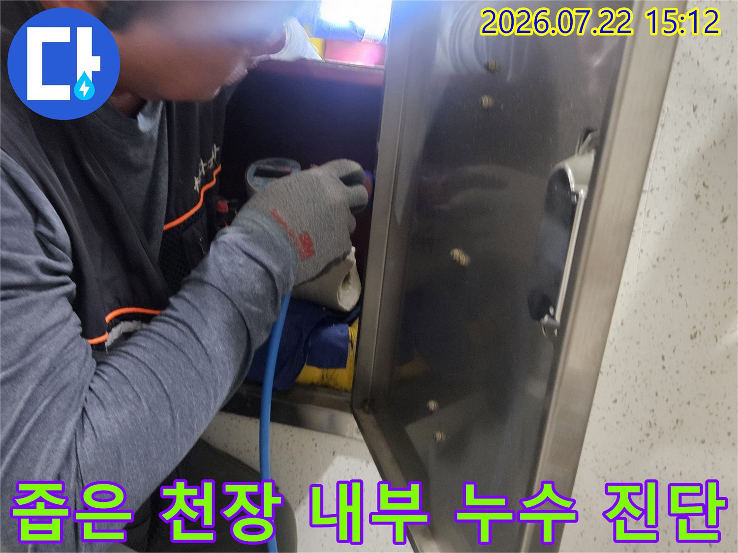 파란색 호스가 연결된 탐지 장비를 사용해 화장실 천장 배관을 점검하는 엔지니어