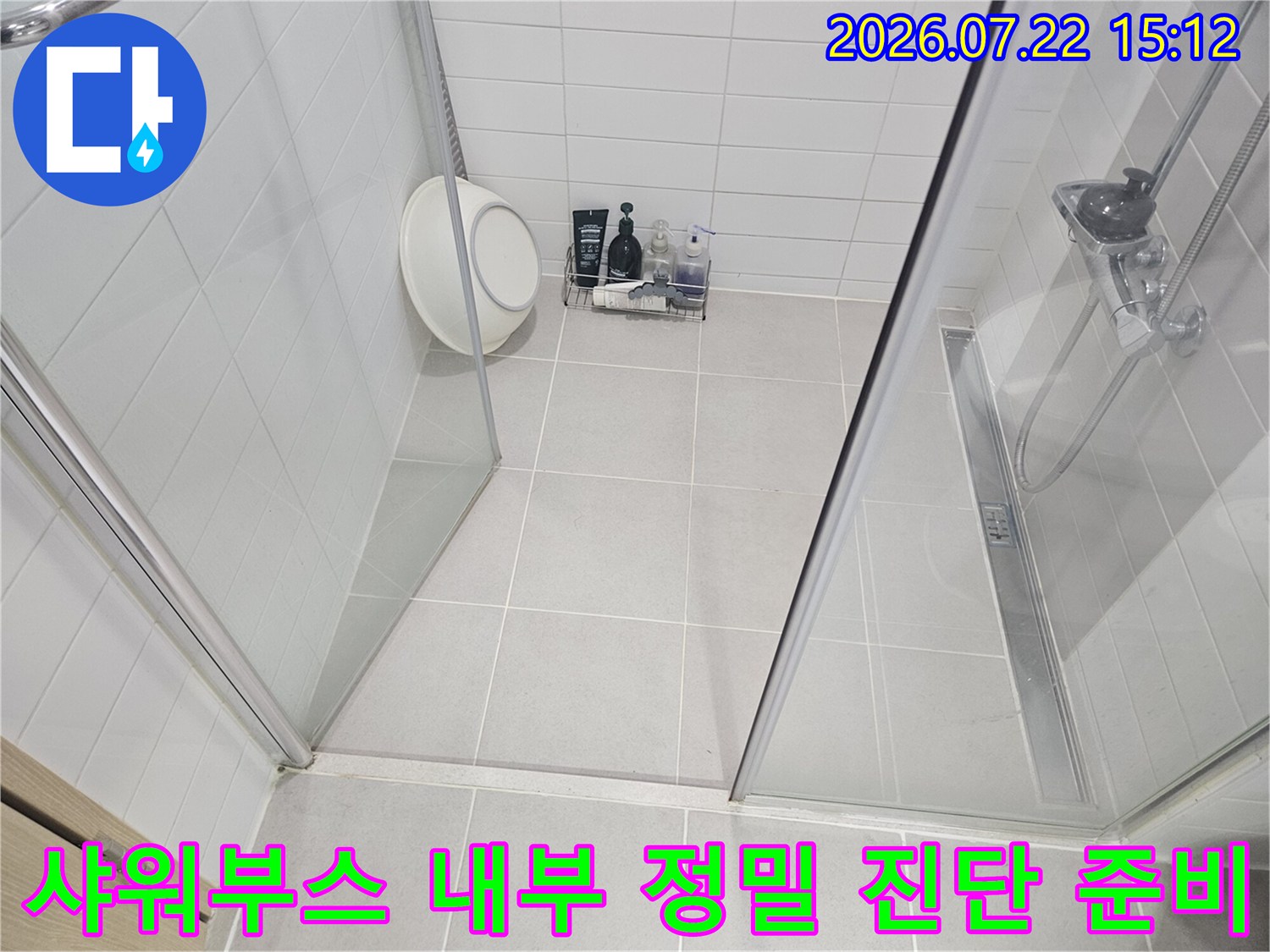 흰색 타일 바닥과 유리벽으로 구성된 샤워실 내부에 배치된 누수 탐지 장비들