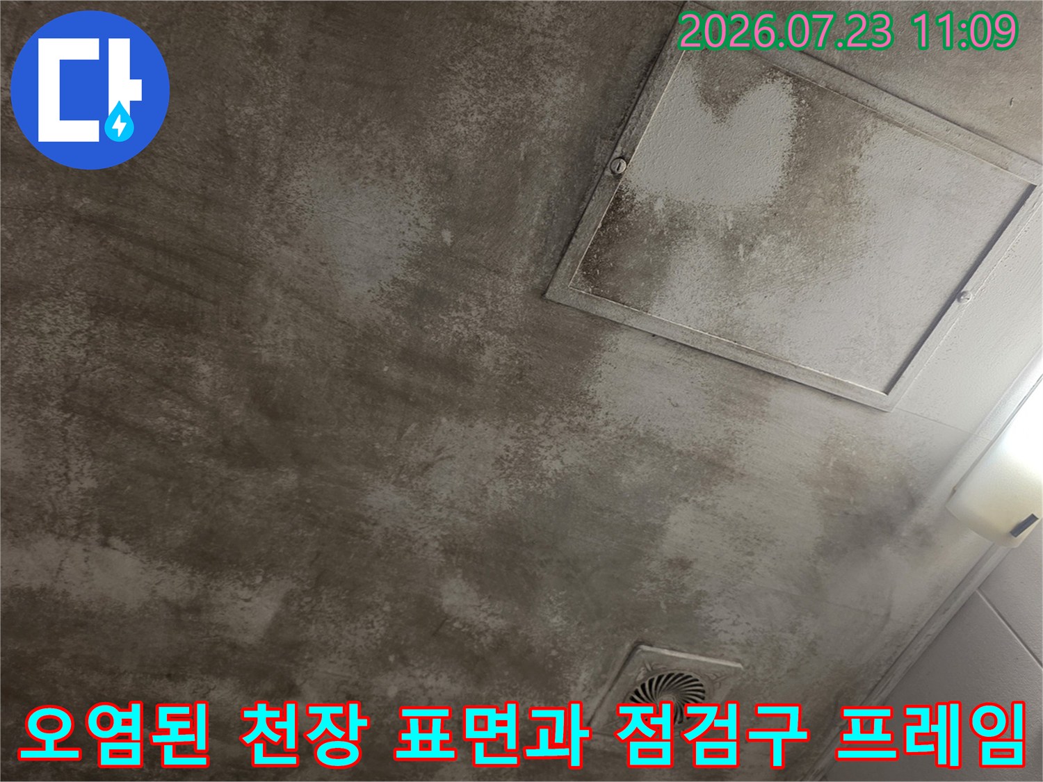 물자국으로 인해 얼룩덜룩해진 회색 천장과 흰색 사각 점검구가 설치된 모습-실제 현장