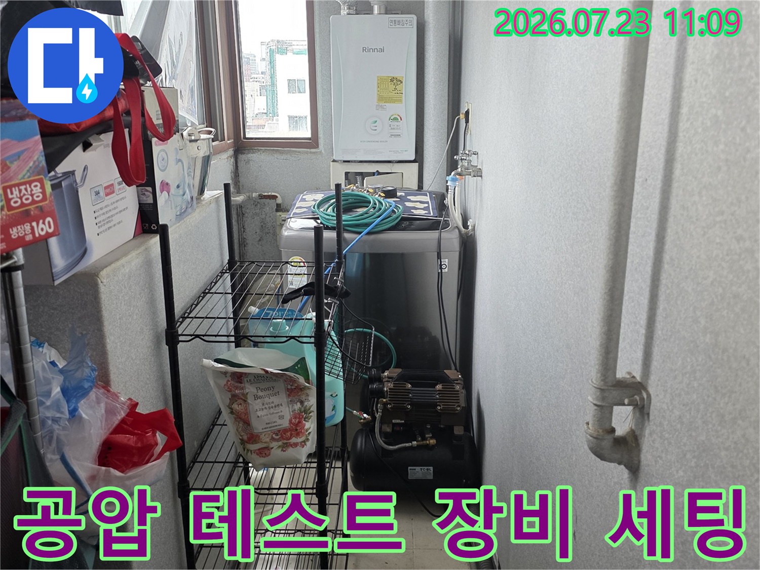 보일러실 선반 아래 배치된 배관 압력 측정용 콤프레샤와 파란색 연결 라인