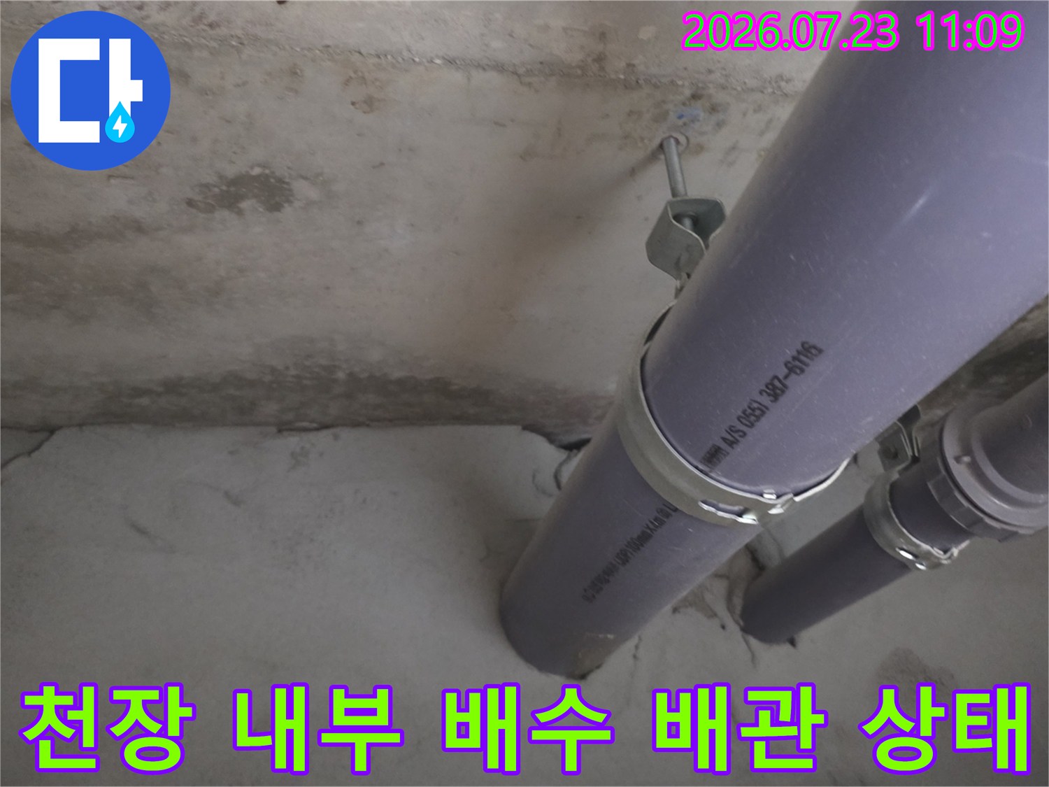 천장 속에 설치된 회색 플라스틱 배관과 고정 밴드-누수 점검 중인 모습