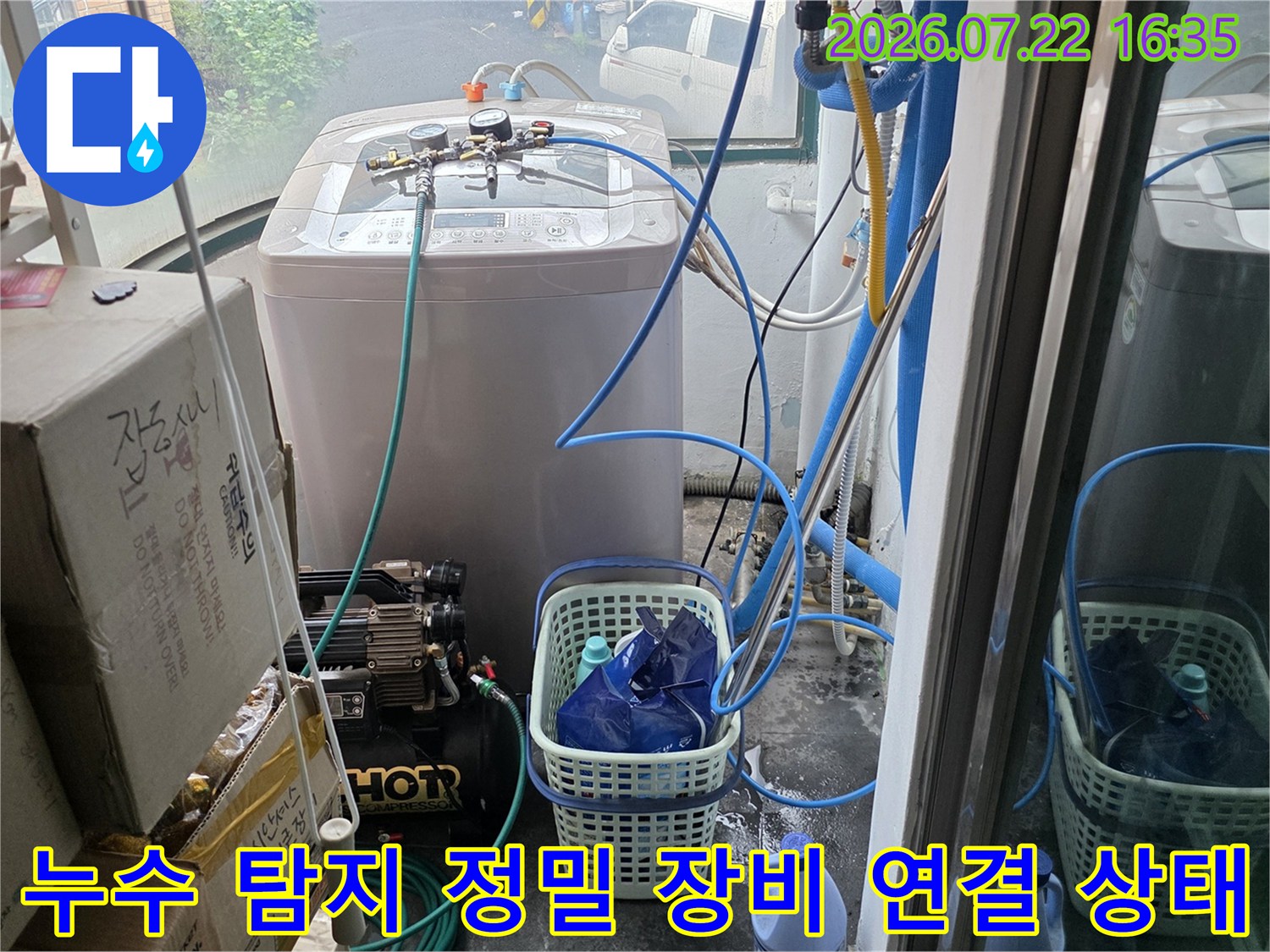 다용도실 내부에 설치된 공압 테스트 장비와 파란색 호스가 복잡하게 연결된 모습