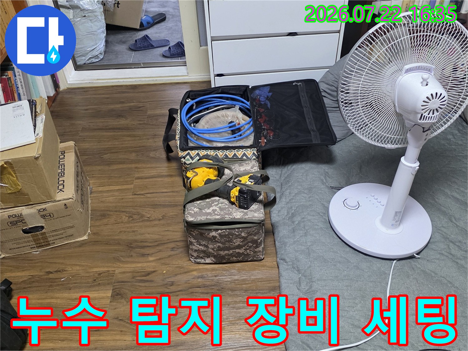 바닥에 놓인 파란색 호스와 전동공구가 담긴 공구함-누수 탐지를 위한 준비 모습