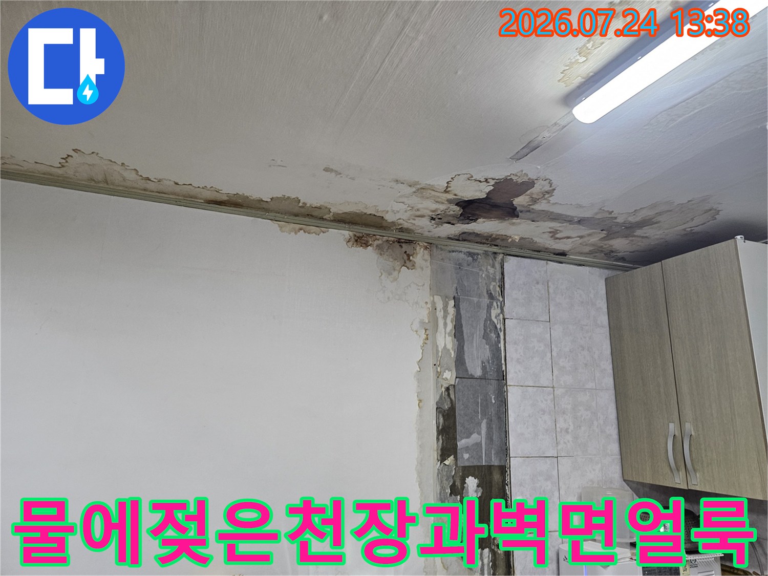 반지하 빌라 주방 천장의 흰색 마감재가 물에 젖어 갈색으로 변색되고 일부가 탈락한 모습