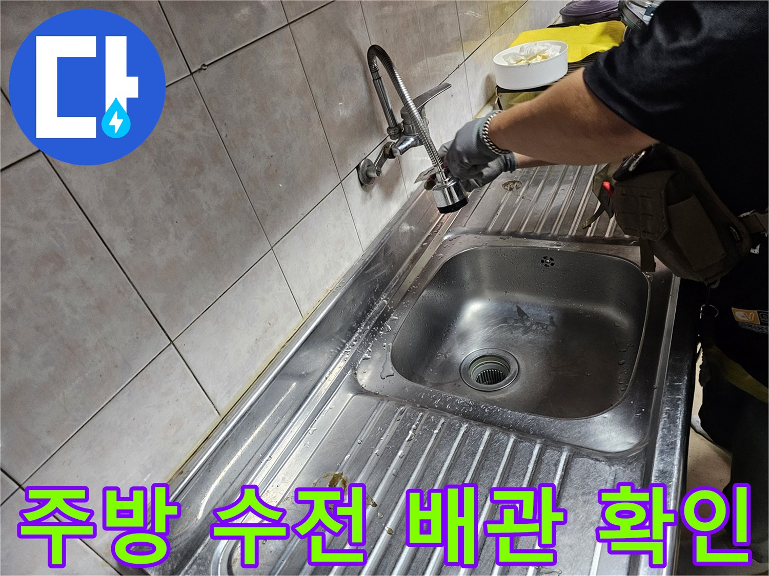 싱크대 하부 수도-연결 부위의 이상 여부를 점검하는 모습입니다.