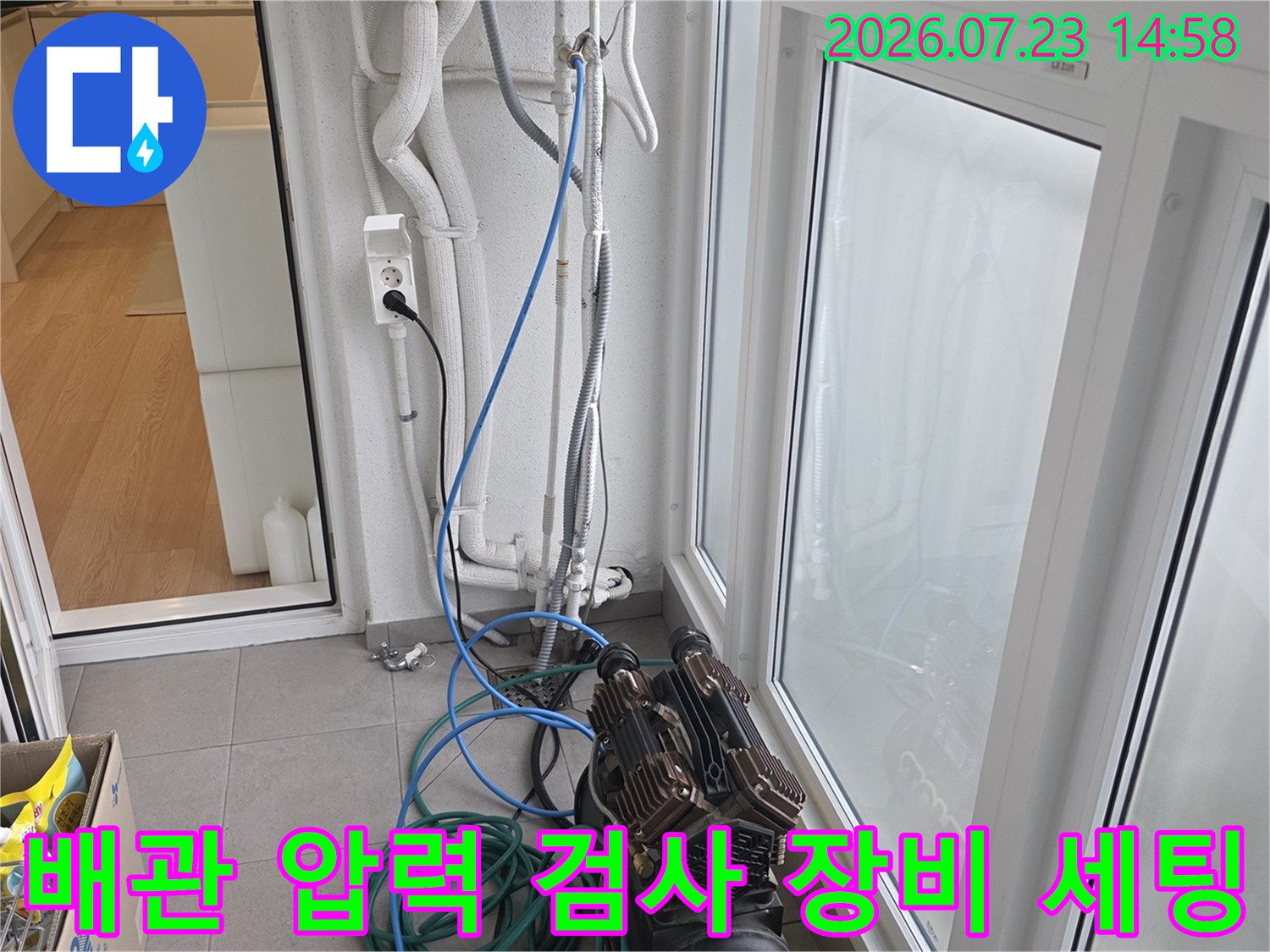 흰색 벽면 배관과 바닥의 파란색 호스가 연결된 누수 탐지 장비-현장 점검 사진