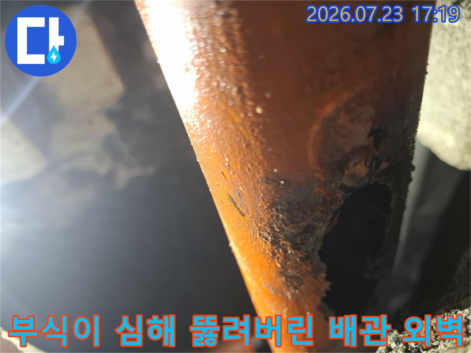 노후로 인해 오렌지색 배관 표면이 부스러지며 큰 구멍이 생긴 모습