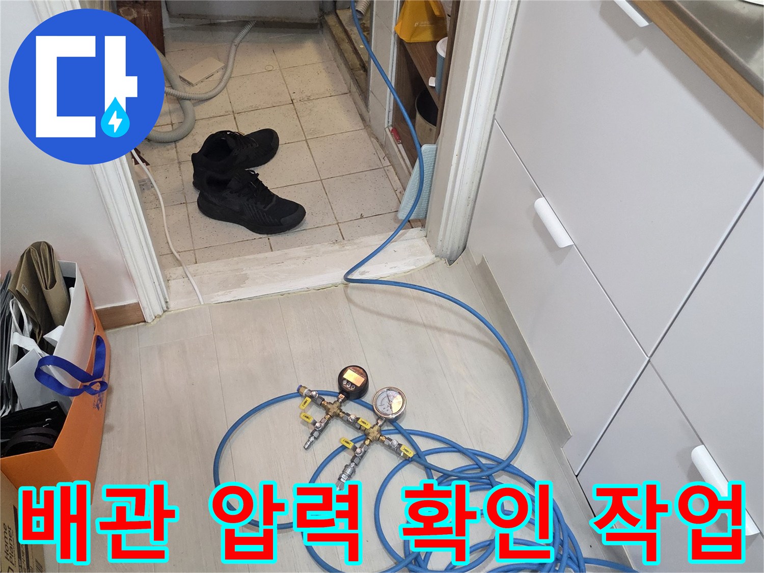 배관에 연결된 파란색 호스와 압력 측정 게이지