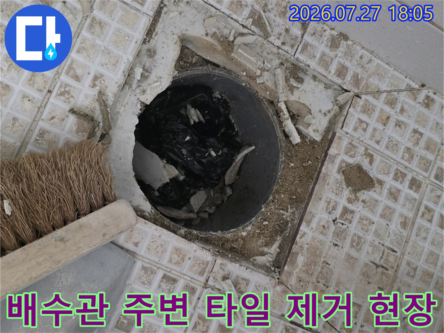 회색-배수관-주변의-하얀색-타일이-뜯겨나가-내부가-노출된-사진