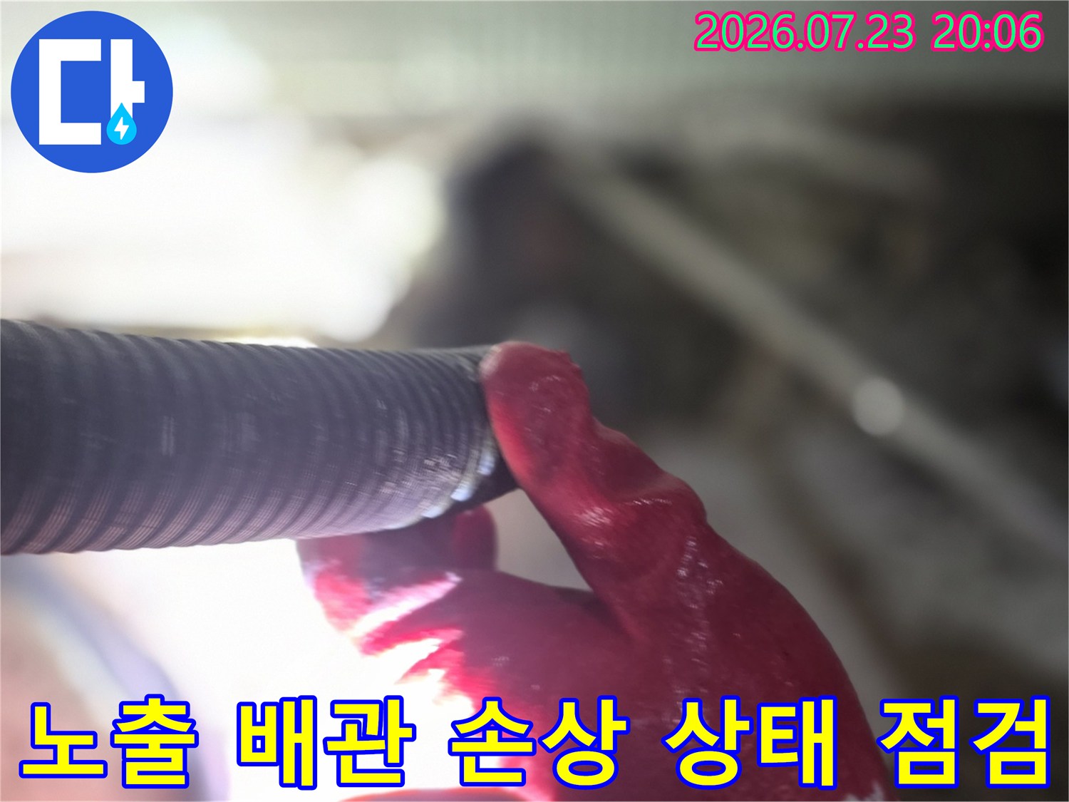 장갑을 낀 채 배관의 연결 부위를 정밀하게 살피는 작업 현장