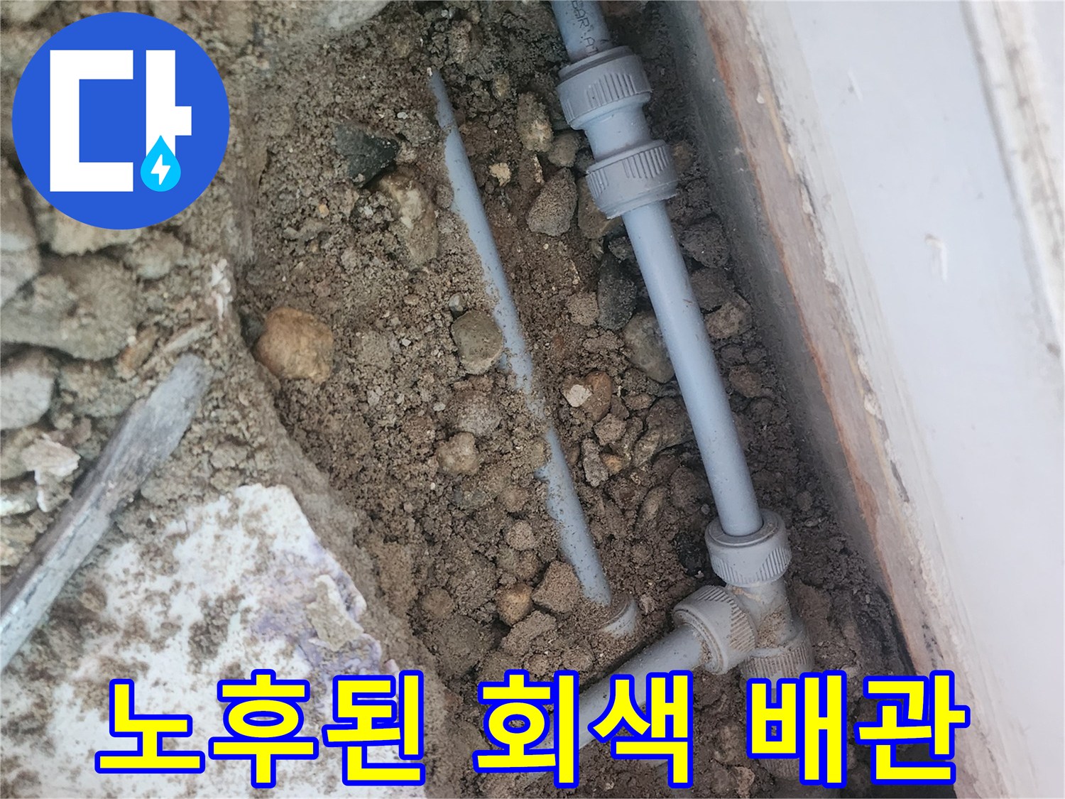 흙 속에 드러난 노후된 회색 수도 배관의 연결 상태