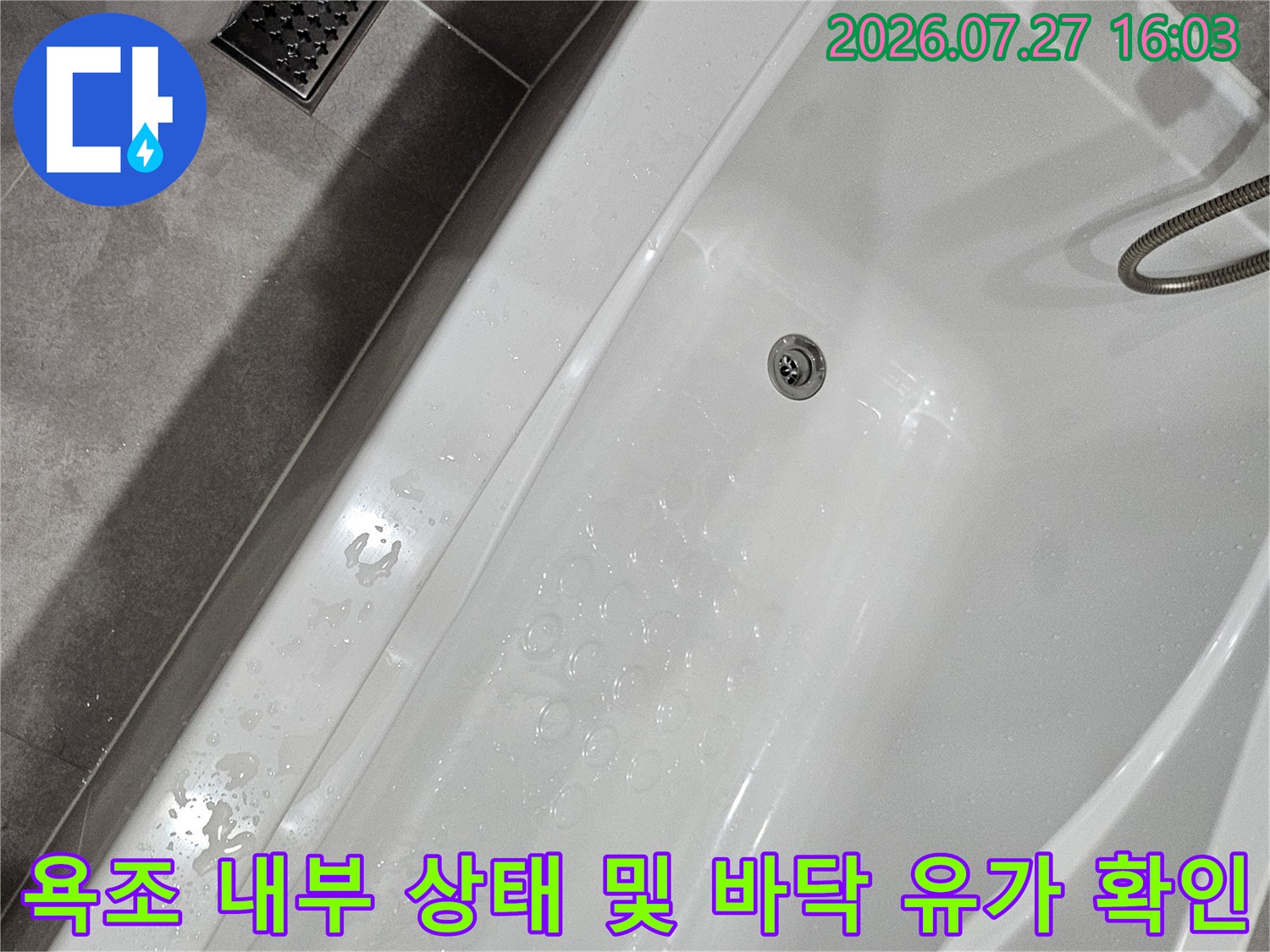 흰색 욕조 속에 위치한 배수구와 주변 타일 마감재의 전반적인 모습
