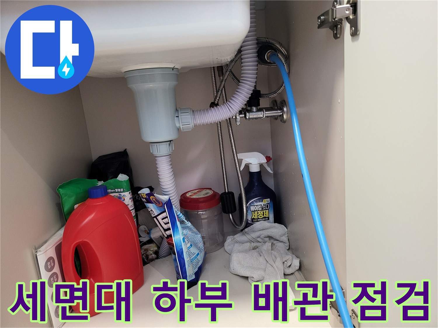 연수구 화장실 세면대 아래쪽의 복잡한 배관과 소모품들이 놓여 있는 모습입니다.