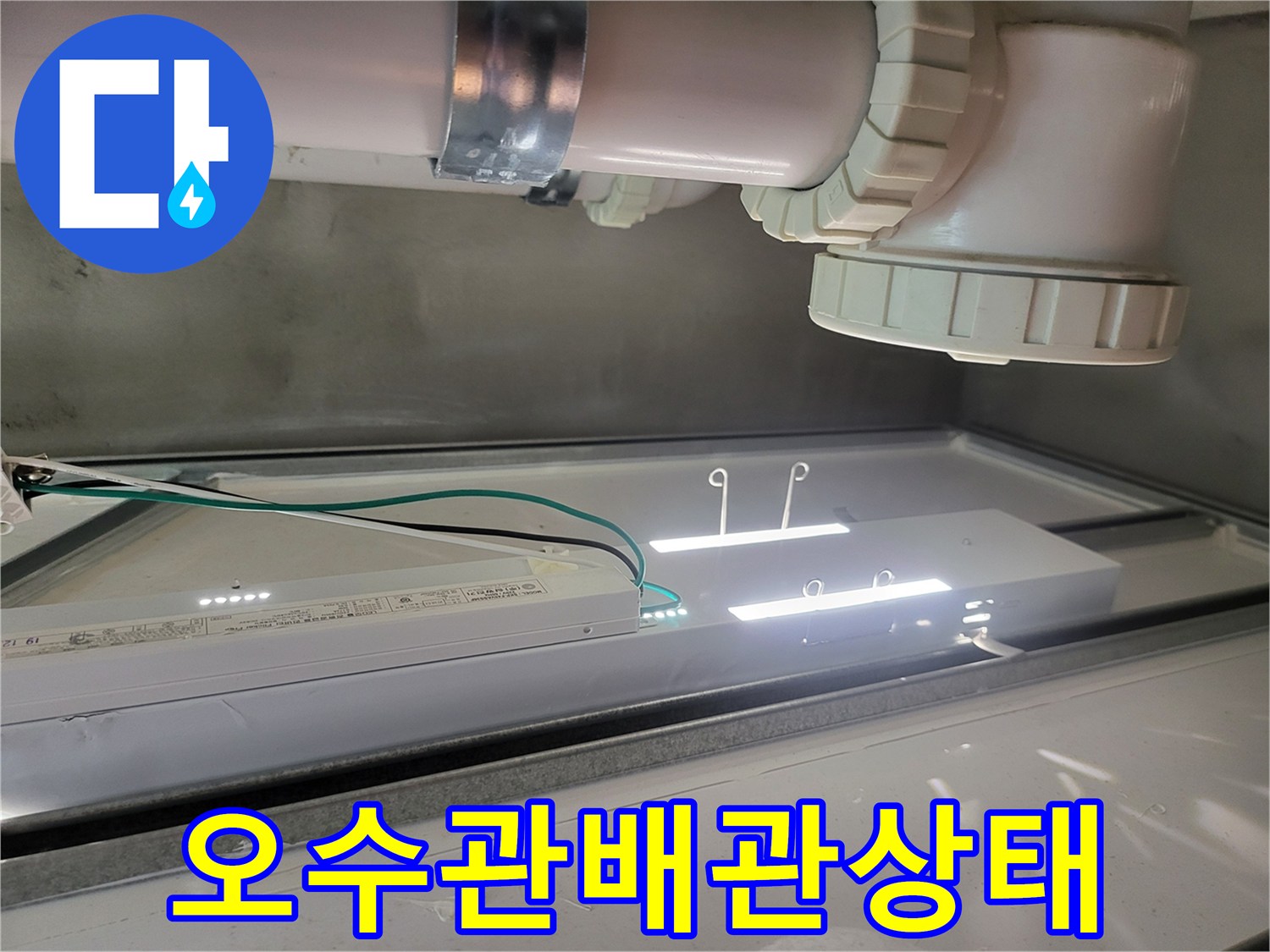 천장 내부 오수 배관과 조명 기구의 근접 촬영