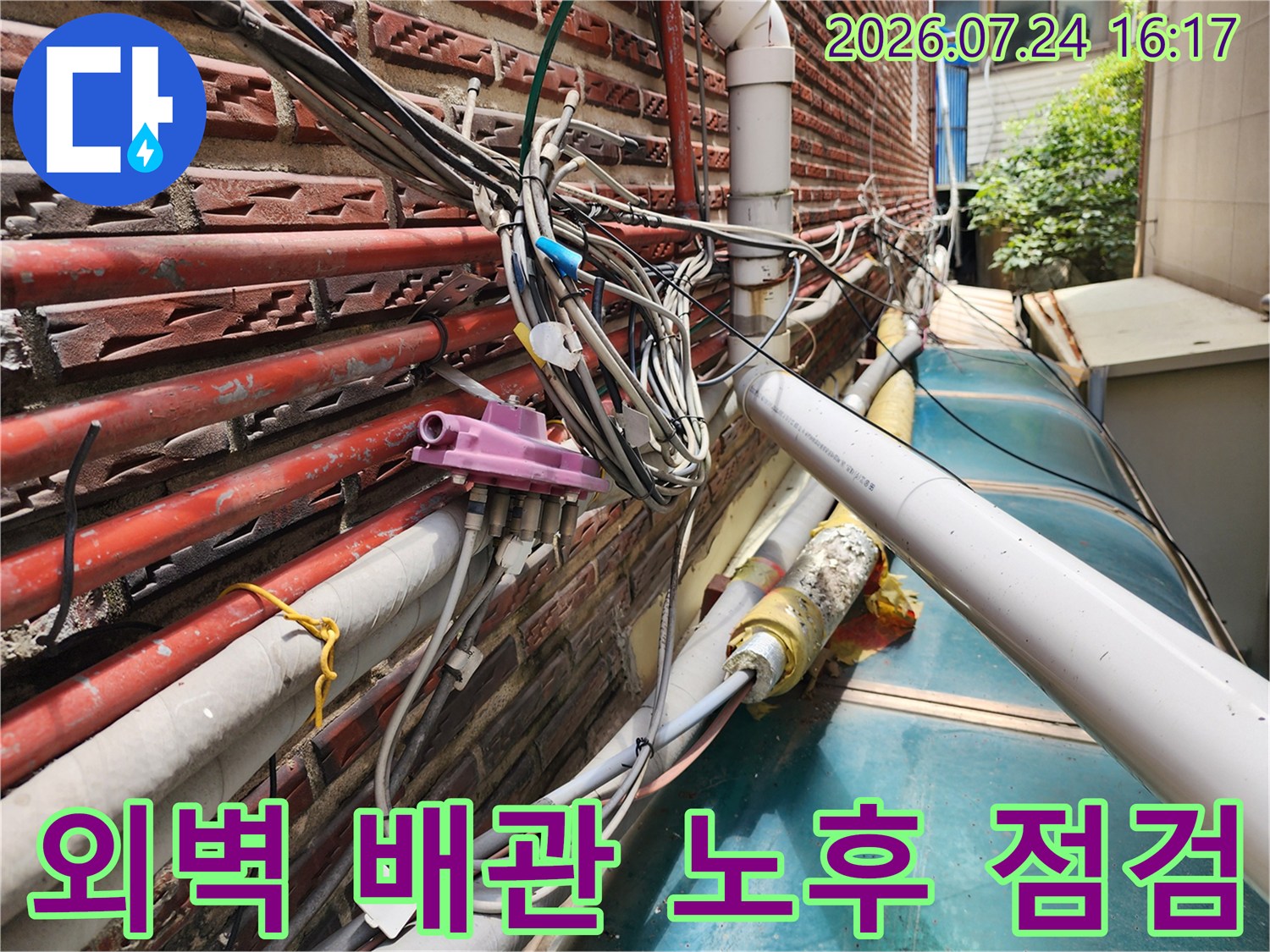붉은 벽돌 외벽에 설치된 수도 및 가스 배관의 연결부와 단열재 상태 확인