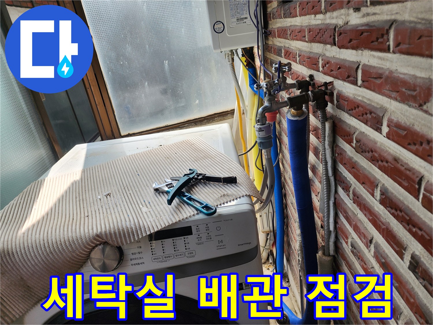 세탁기 옆 외벽에 노출된 파란색 수도 배관과 부속품 상태를 확인하는 모습