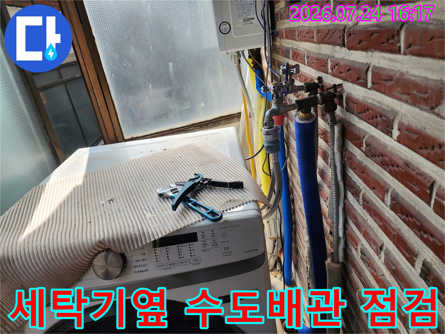 세탁기가 놓인 공간 옆 벽면에 노출된 파란색 및 은색 단열재 배관 점검 모습