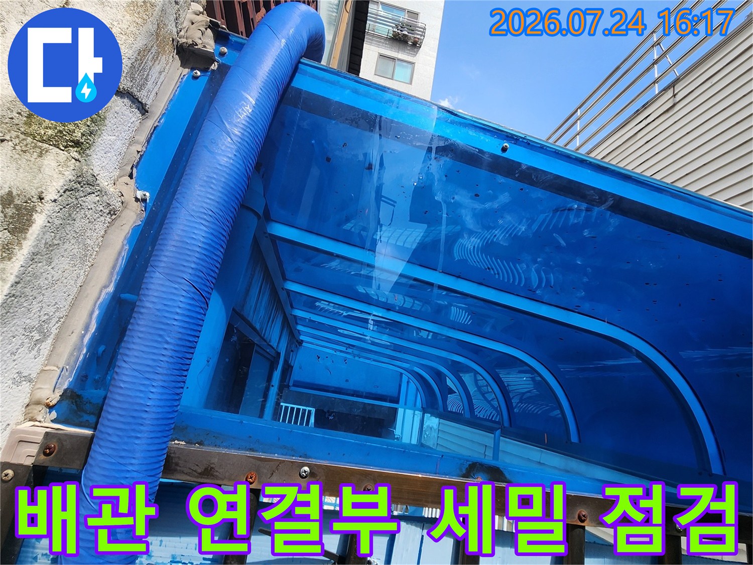 파란색 보온재와 금속 지지대 구조의 외벽 배관 확대 사진