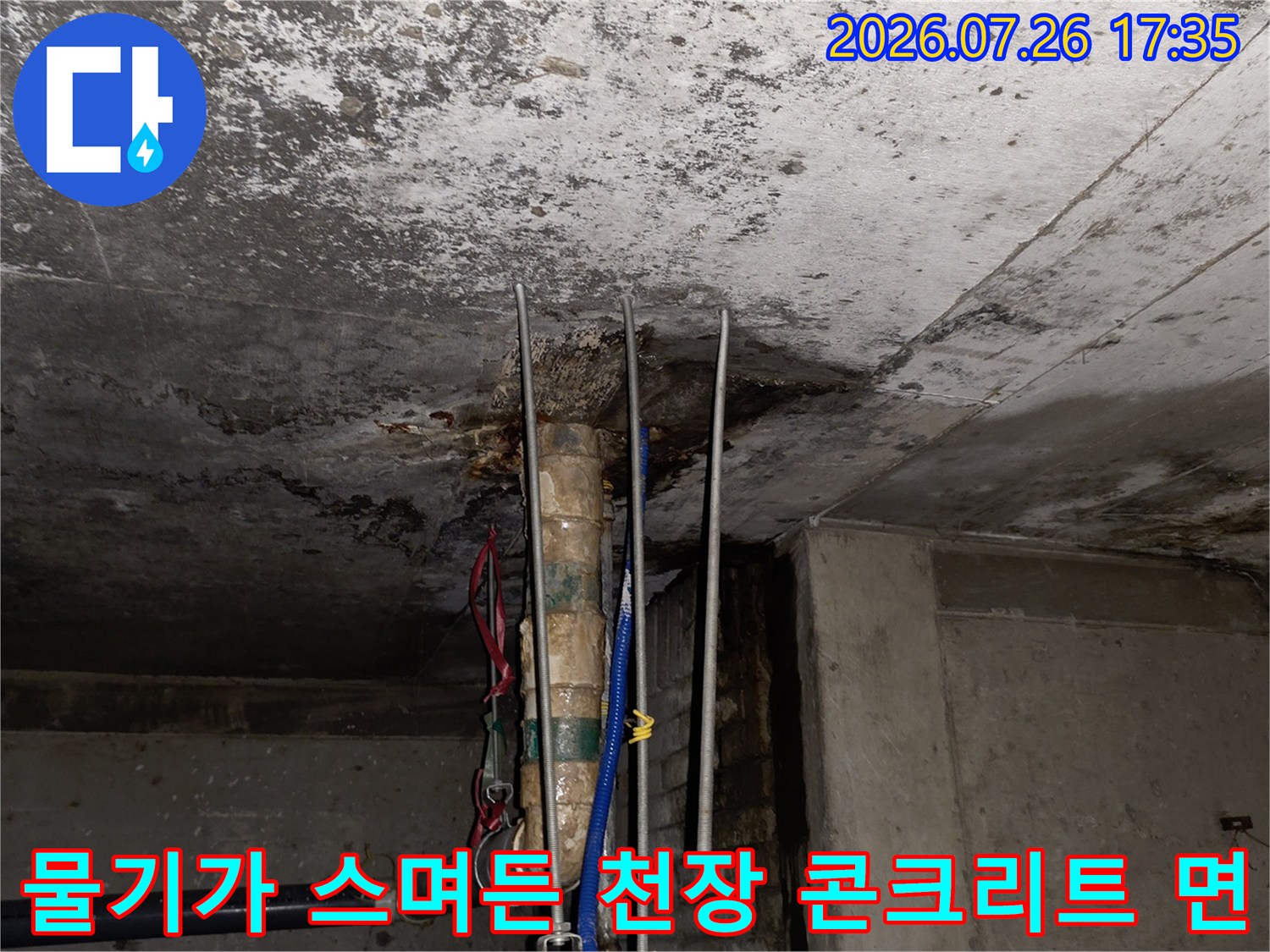천장에서 내려오는 파이프 주변으로 습기로 인해 오염된 콘크리트 표면 모습
