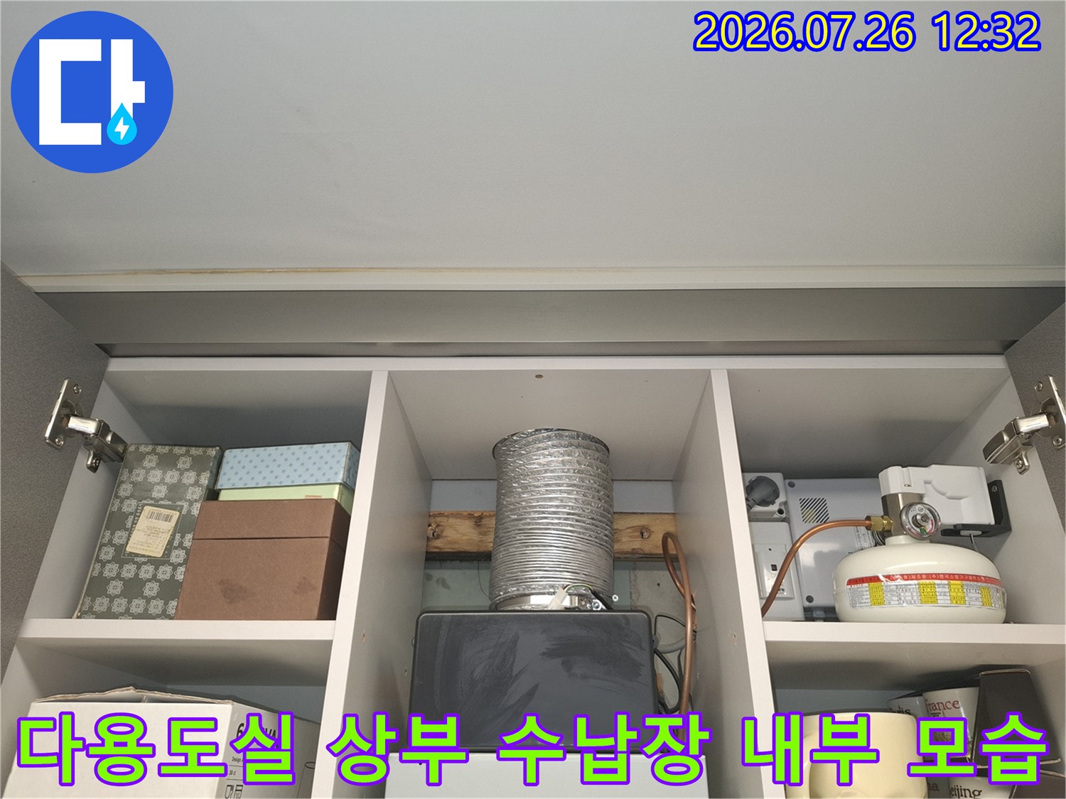 다용도실-수납장-내부에-설치된-은색-자바라-배관과-가스보일러-부속품들
