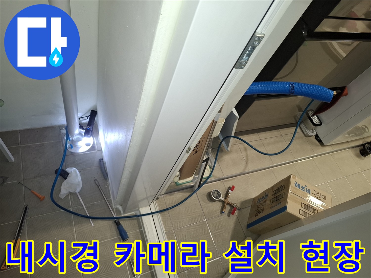 세탁실 바닥-배관 내부 결함을 찾기 위해 배치된 내시연 장비와 도구들