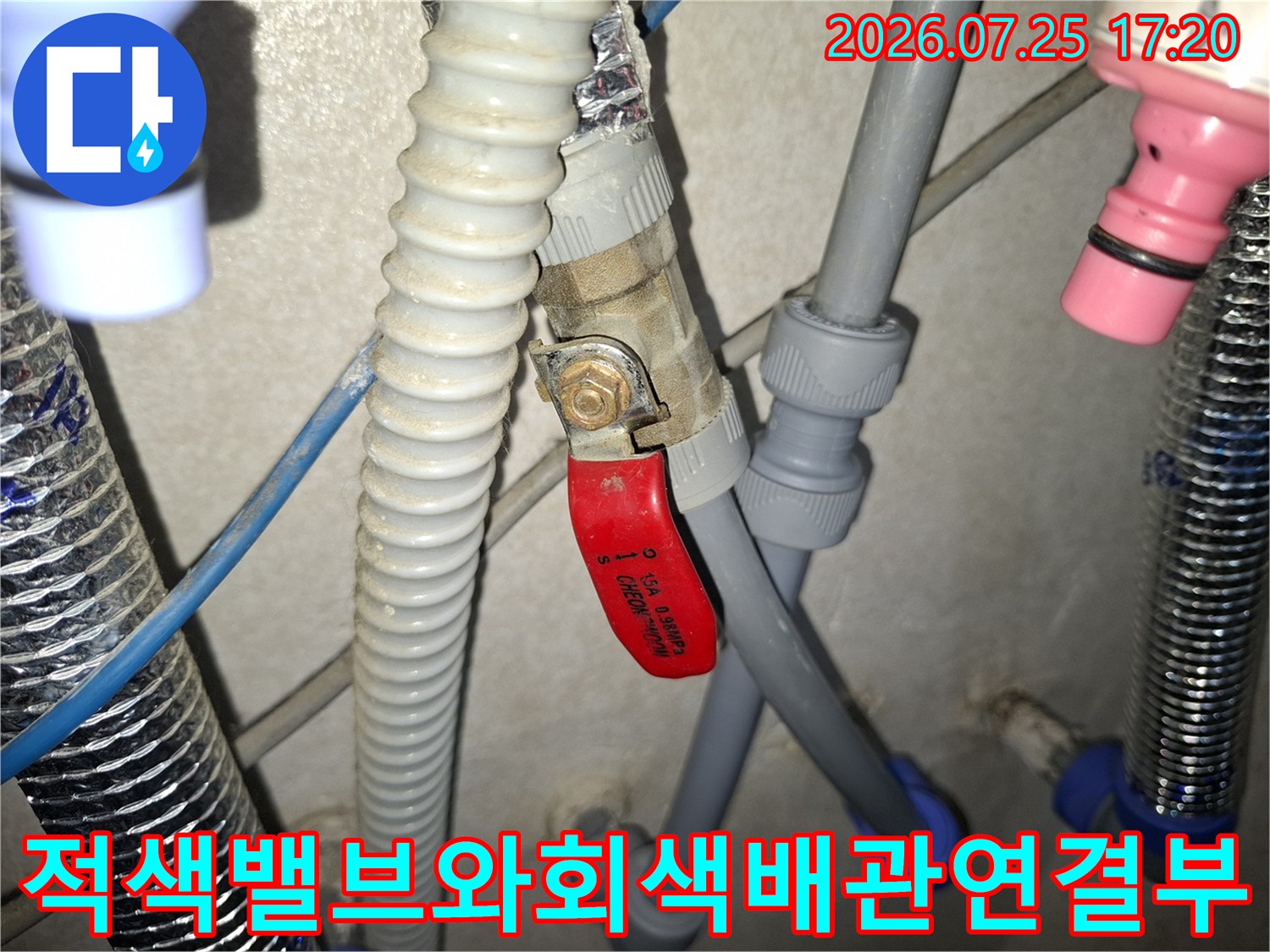 회색 플라스틱 배관과 적색 핸들 밸브가 연결된 부위의 누수 점검 모습