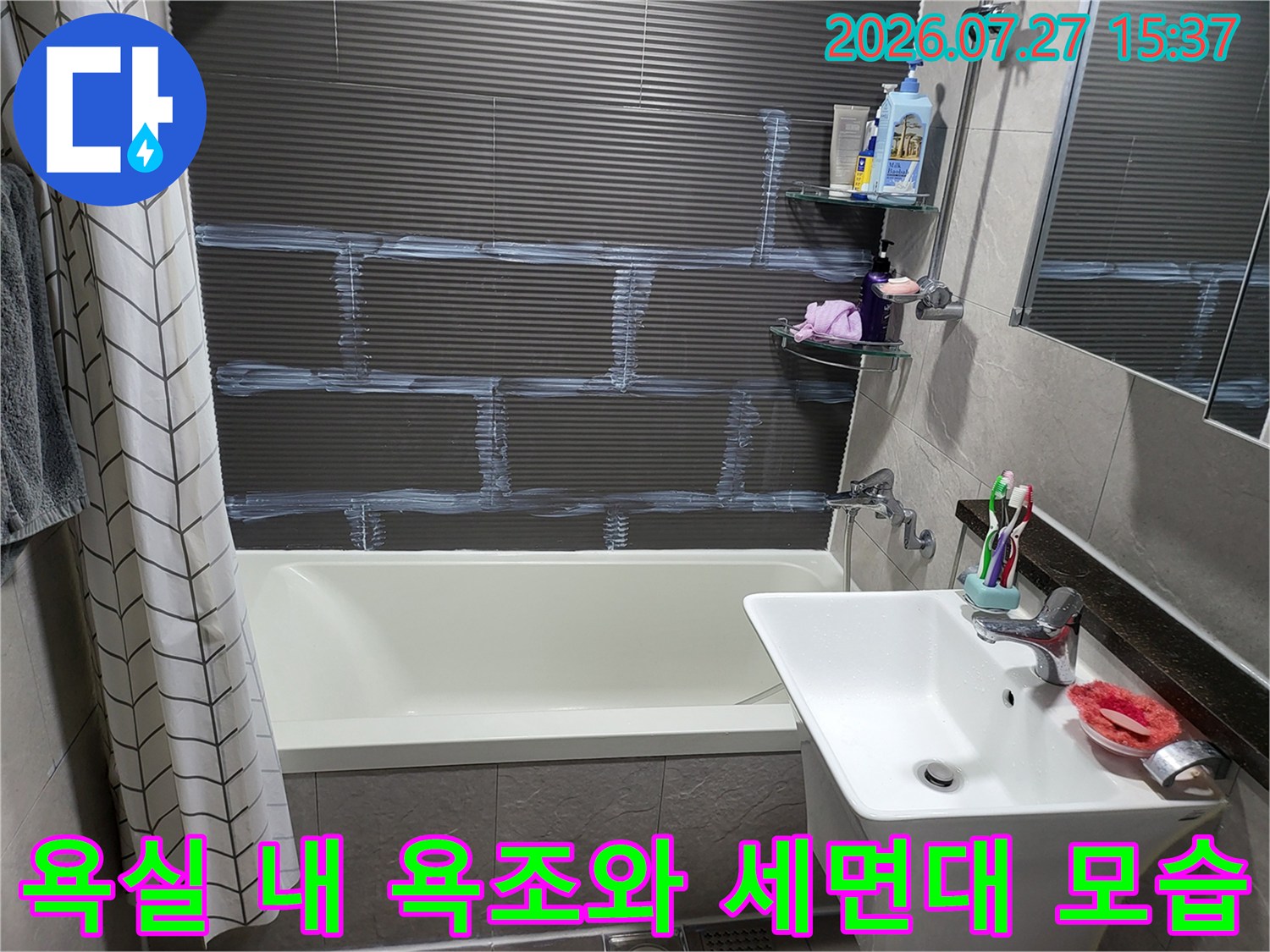 짙은 회색 타일 벽과 흰색 위생도기가 설치된 화장실-전체적으로 깔끔한 상태의 내부 사진