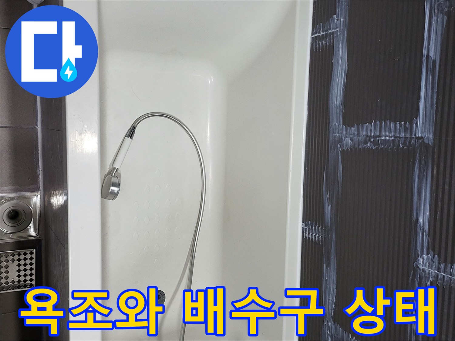 하얀색 욕조 내부에 보이는 배수구와 샤워기 호스 모습