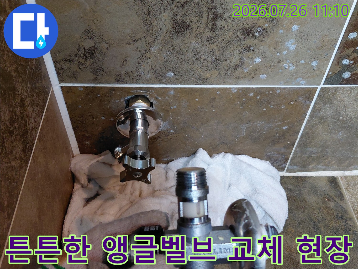 화장실 벽면에 설치된 수전용 앵글밸브를 새것으로 교체하는 장면