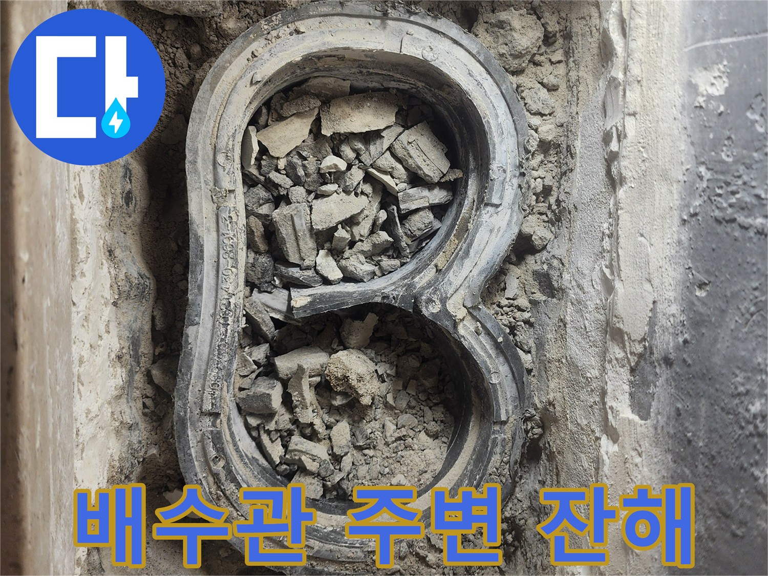 배수 파이프 입구에 쌓여 있는 깨진 시멘트와 폐자재