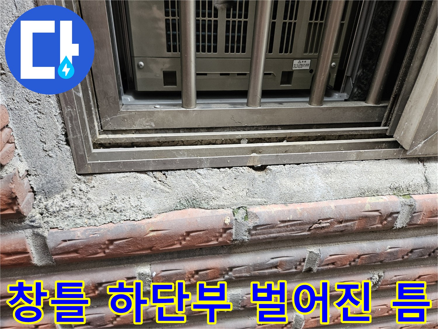 창문 프레임 아래쪽 벽면의 갈라진 틈새를 근접 촬영한 사진입니다.