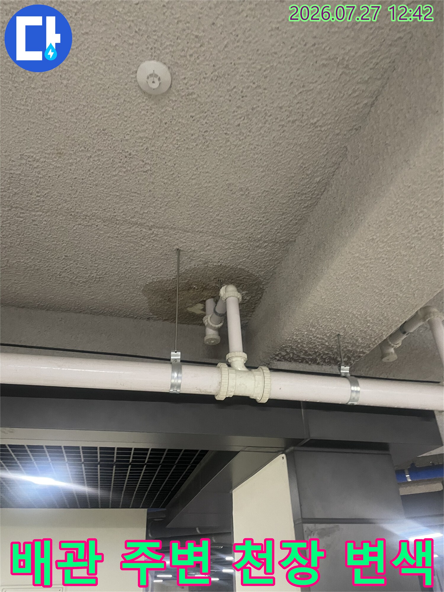흰색 PVC 배관과 천장 마감재 사이에 발생한 누수성 오염 부위 사진