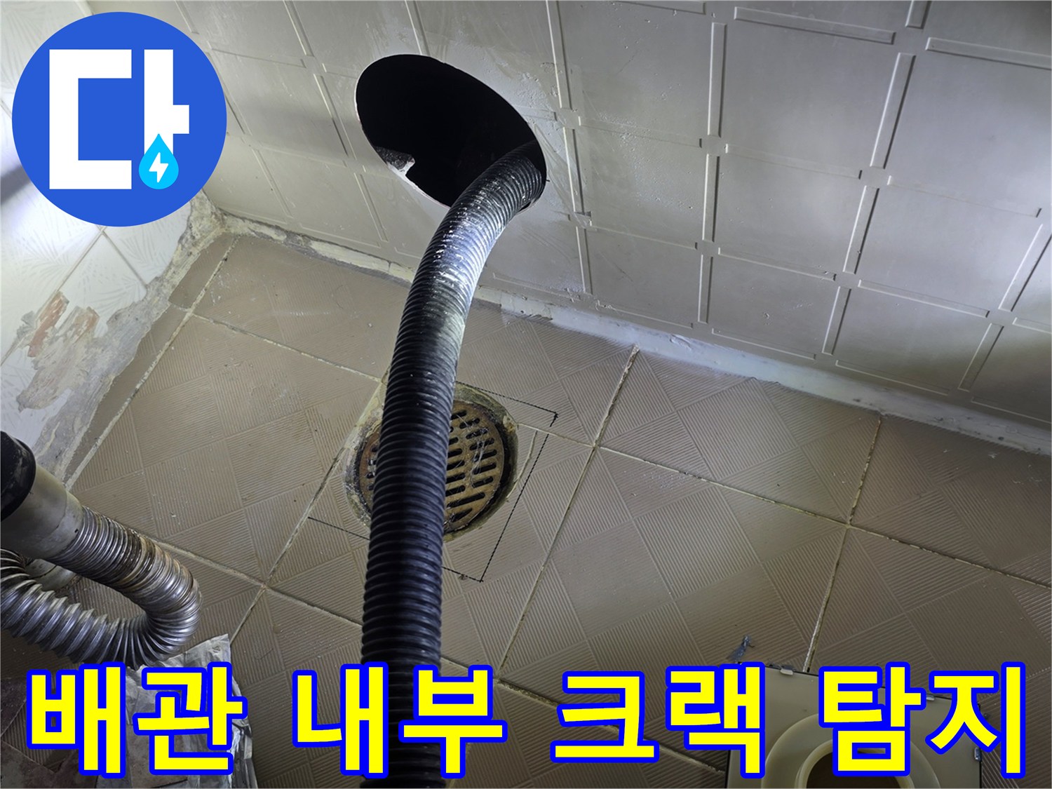 검정색 내시경 호스가-하수구 구멍을 통해 배관 안쪽으로 진입하고 있습니다.
